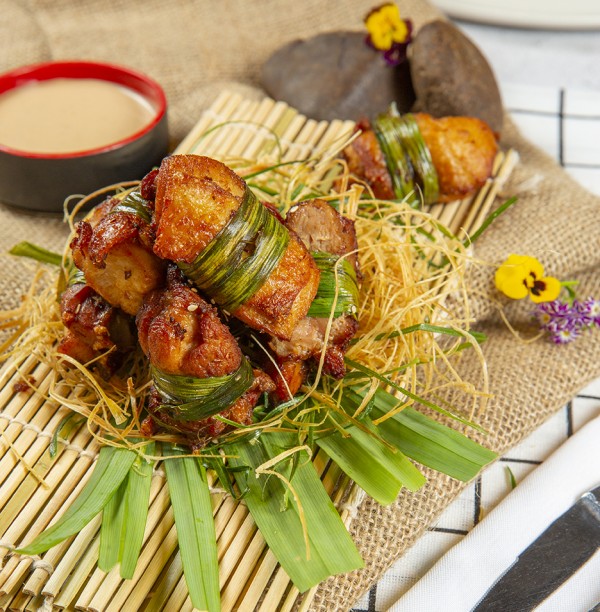 Boneless chicken wrapped in pandan leaves, mixed greens, peanut sauce