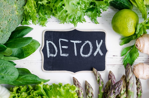 Detox concept with green vegetables: spinach, lettuce, cucumber, ginger, asparagus, broccoli and lime. White wooden background. Clean eating Vegetarian food Healthy fitness lifestyle. Top view.