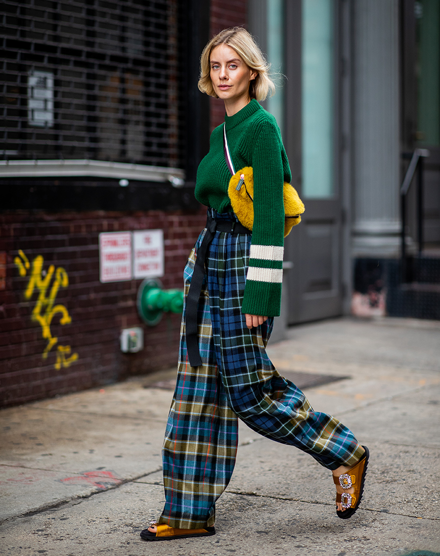 NEW YORK, NY - SEPTEMBER 12: Lisa Hahnbueck wearing checked pants Tibi, green knit Baum und Pferdgarten, yellow fake fur belt bag, sandals Roger Vivier is seen during New York Fashion Week Spring/Summer 2019 on September 12, 2018 in New York City. (Photo by Christian Vierig/Getty Images)