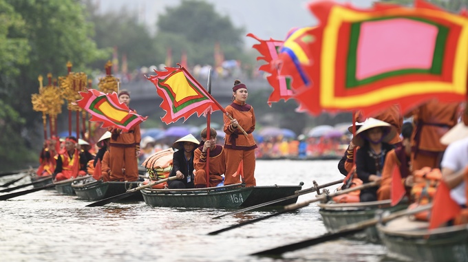 Đoàn cờ phướn nối đuôi trên sông trong hình ảnh nghĩa quân phất cờ hào hùng.