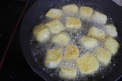 Bước 2: Bắc chảo lên bếp, đổ dầu ăn vào đun nóng già rồi cho đậu phụ vào rán chín, vàng đều thì vớt ra đĩa.