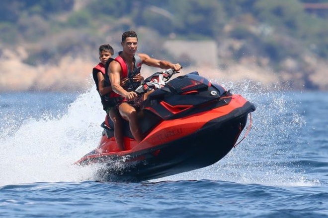 Cậu nhóc Cristiano Ronaldo Jr. ôm chặt trong khi bố lái môtô nước. Biển Saint Tropez là nơi lý tưởng để du khách trải nghiệm các trò lướt ván buồm, chèo thuyền cùng các môn thể thao dưới nước như trượt nước, lặn bình khí... 