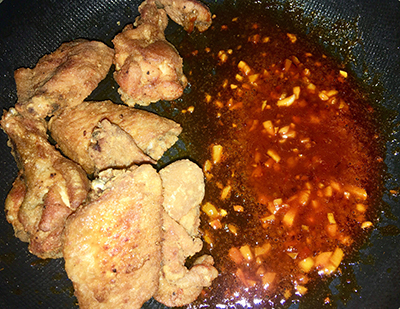 Bước 3: Lấy một chảo khác, phi thơm tỏi cho sốt vào nấu sôi lên. Khi nào sốt sôi thì tắt bếp, cho gà vào trộn đều để sốt phủ hết gà.