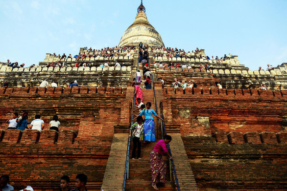 Du khách chờ ngắm hoàng hôn từ đỉnh chùa Shwesandaw ở Bagan. Ngắm hoàng hôn hay bình minh trên nóc các ngôi chùa là một trong những điều thu hút du khách nhưng có hại cho các ngôi chùa - Ảnh: REUTERS