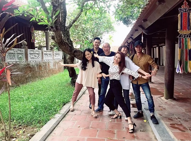 Đạo diễn Danh Dũng (giữa) và giám đốc sản xuất Nguyễn Bá Thành (áo vàng) chụp ảnh cùng dàn diễn viên khi thực hiện phân đoạn các con gái tìm gặp ông Sơn ở chùa.