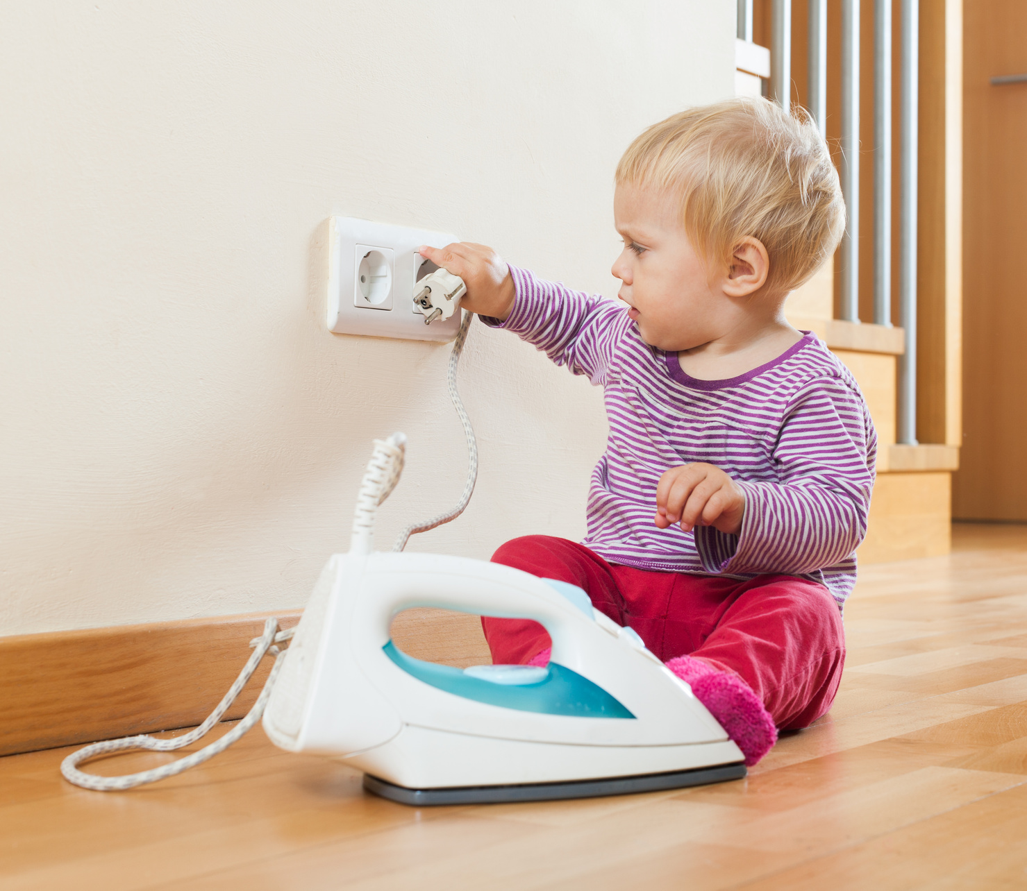 Toddler  playing with electric iron at home