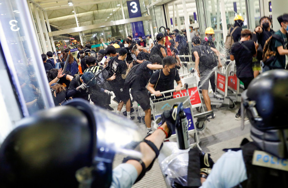 Cảnh sát Hong Kong đụng độ với người biểu tình ở sân bay Hong Kong tối 13-8 - Ảnh: REUTERS