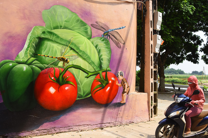 Các sản phẩm nông nghiệp như rau, củ quả gắn liền với công việc hàng ngày của người dân địa phương được thể hiện sinh động trên tường.