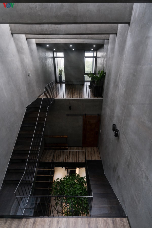 Cầu thang nằm ở giữa nhà được thiết kế như một giếng trời, và là sự kết nối với các không gian khác. Điểm gây ấn tượng của ngôi nhà chính là màu xám của bê tông trần và tường xi măng mài không sơn. Màu xám này đi xuyên suốt ngôi nhà.