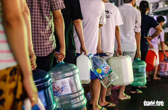 Người dân xếp hàng đến tối mịt 16-10 để lấy nước sạch tại khu đô thị Linh Đàm, Hà Nội - Ảnh: NGUYỄN KHÁNH