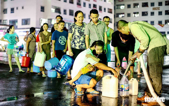Người dân xếp hàng đến tối mịt để được nhận nước sạch (ảnh chụp tại khu đô thị Linh Đàm chiều tối 16-10) - Ảnh: NGUYỄN KHÁNH