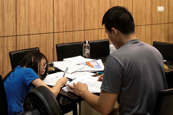 Một học sinh học bài với gia sư tại nhà em - Ảnh: AFP