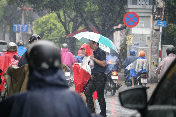 Người dân đi dưới trời mưa trên đường Hồ Văn Huê, Q.Phú Nhuận, TP.HCM sáng 11-11 - Ảnh: NGỌC PHƯỢNG
