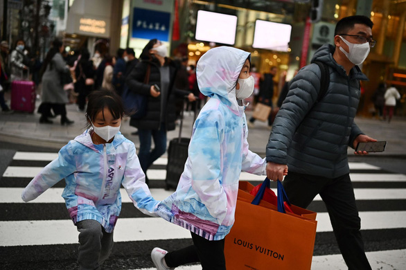Khách mua hàng cẩn thận đeo khẩu trang ở khu Ginza ở Tokyo (Nhật) - Ảnh: AFP