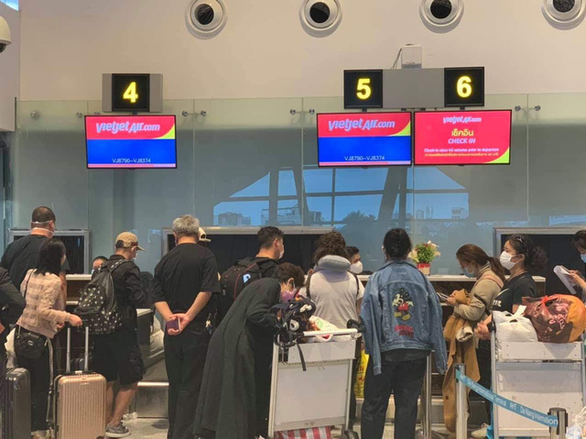 Đoàn khách về TP Vũ Hán (Trung Quốc) đeo khẩu trang lúc làm thủ tục tại sân bay Đà Nẵng - Ảnh: V.B