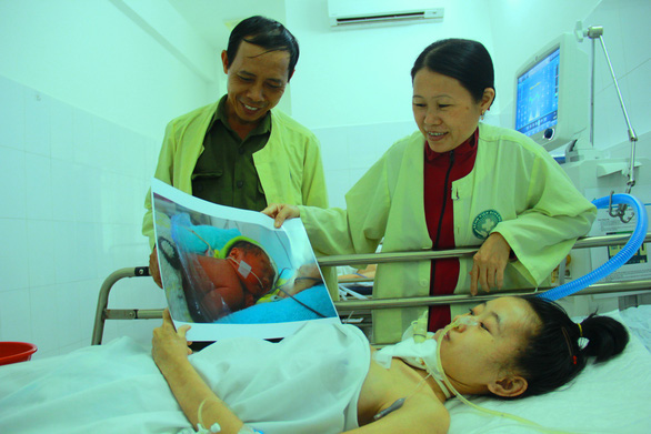 Ba ngày sau khi sinh con, Tú Cẩm được gặp con qua ảnh do phóng viên báo Tuổi Trẻ chụp và in ra, chuyển từ Bệnh viện Sản nhi Đà Nẵng sang Bệnh viện Đa khoa Đà Nẵng (ảnh chụp ngày 16-8-2018)