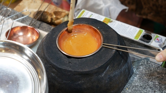 Cách làm kẹo dalgona ở Hàn Quốc, dùng một chảo nhỏ đun chảy hỗn hợp baking soda và đường là xong, có vị giống caramel.