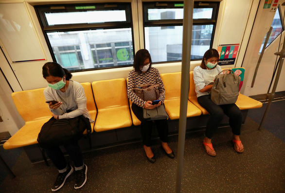 Hành khách đeo khẩu trang và ngồi cách nhau một ghế theo khuyến cáo y tế về phòng dịch COVID-19 của Bộ Y tế Thái Lan khi đi phương tiện giao thông công cộng ở Bangkok - Ảnh: REUTERS