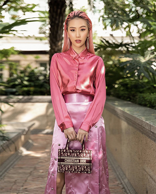 Quỳnh Anh Shyn phủ kín sắc hồng cho hình ảnh của cô từ màu của tóc cho đến áo lụa bóng, chân váy và túi Dior sang chảnh.
