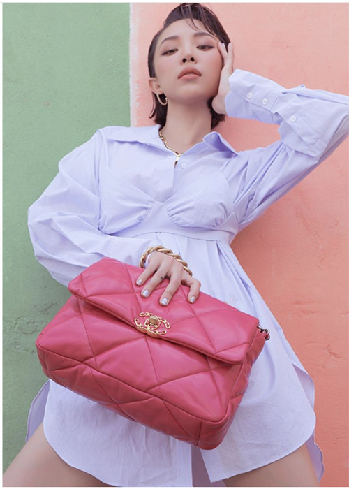 Diện váy sơ mi biến tấu với những đường nét phá cách ngoạn mục, Tóc Tiên chọn túi Chanel tông hồng nữ tính để tạo điểm nhấn.