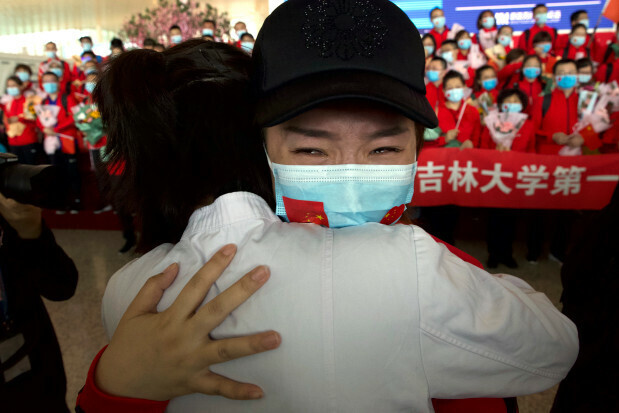 A medical worker from China's Jilin Province reacts as she prepares to return home at Wuhan Tianhe International Airport in Wuhan in central China's Hubei Province, Wednesday, April 8, 2020. Within hours of China lifting an 11-week lockdown on the central city of Wuhan early Wednesday, tens of thousands people had left the city by train and plane alone, according to local media reports. (AP Photo/Ng Han Guan)