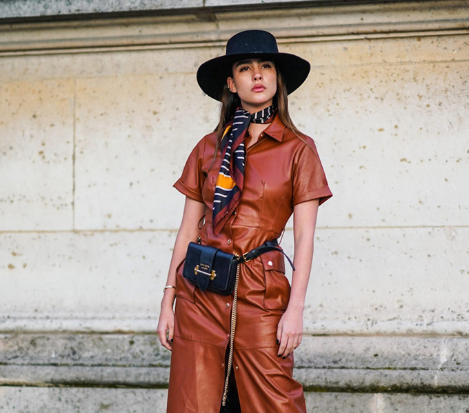 PARIS, FRANCE - OCTOBER 01: A guest wears a hat, a colored scarf, a brown leather dress, a Prada belt bag with a golden chain, fluffy black pants, outside Louis Vuitton, during Paris Fashion Week - Womenswear Spring Summer 2020, on October 01, 2019 in Paris, France. (Photo by Edward Berthelot/Getty Images)