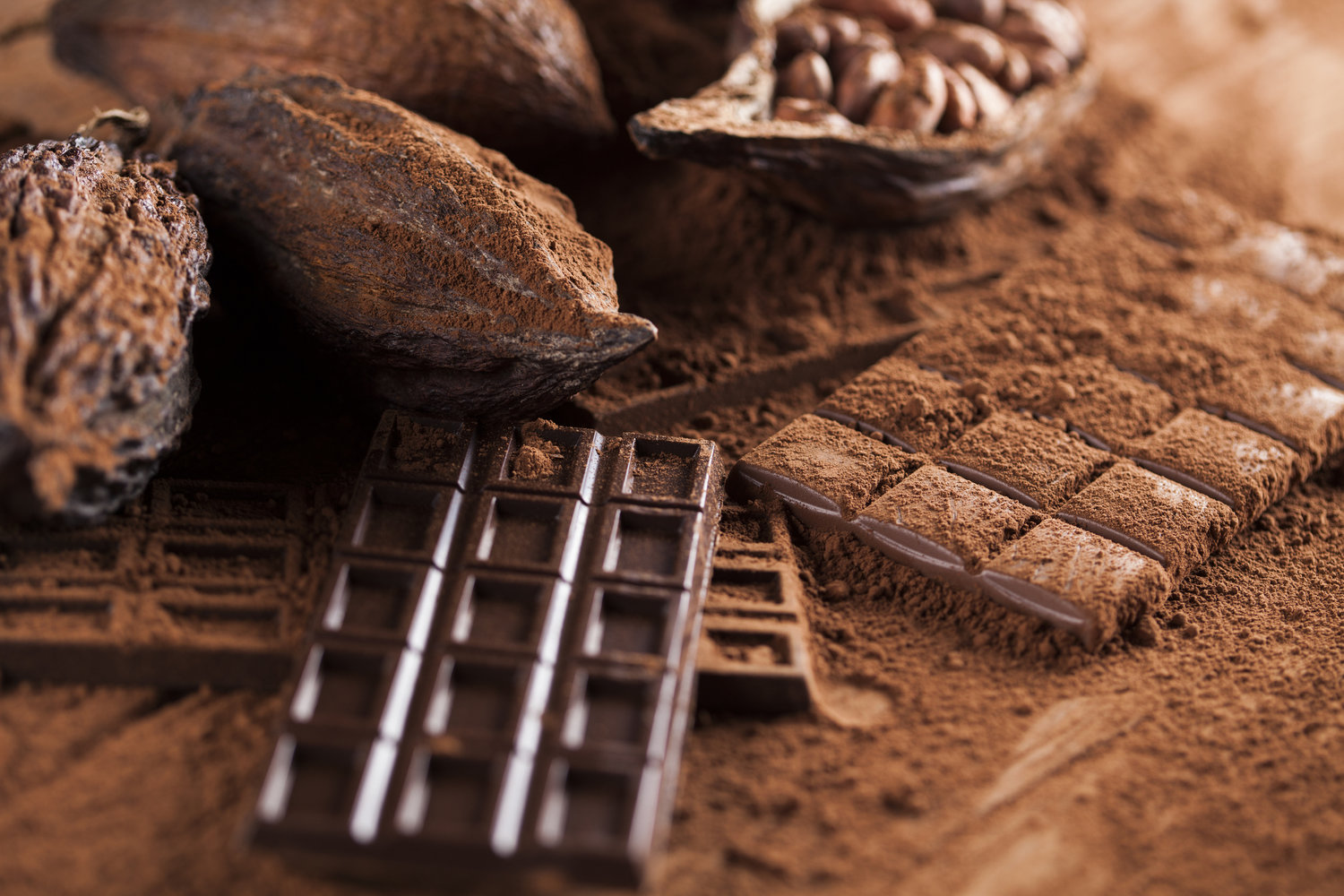 Chocolate bar, candy sweet, cacao beans and powder on wooden background