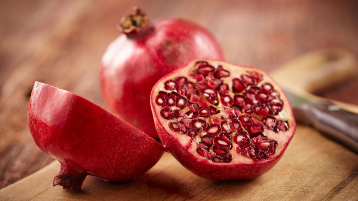 pomegranate-fruit-on-cut-board-157685468-588901525f9b5874ee801d3e-15998221216912139335444