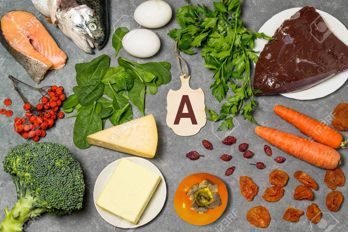 Food is source of vitamin A. Various natural food rich in vitamins. Useful food for health and balanced diet. Prevention of avitaminosis. Small cutting board with name of vitamin A. Top view