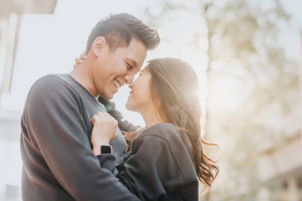 Happy Asian couple in love having fun and embracing outdoor in city